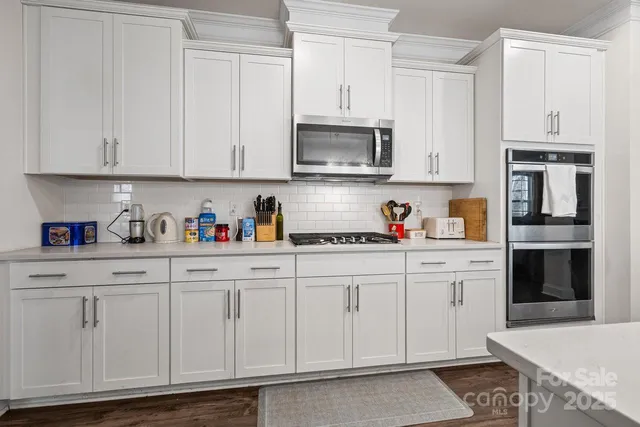 a kitchen with white cabinets and white appliances