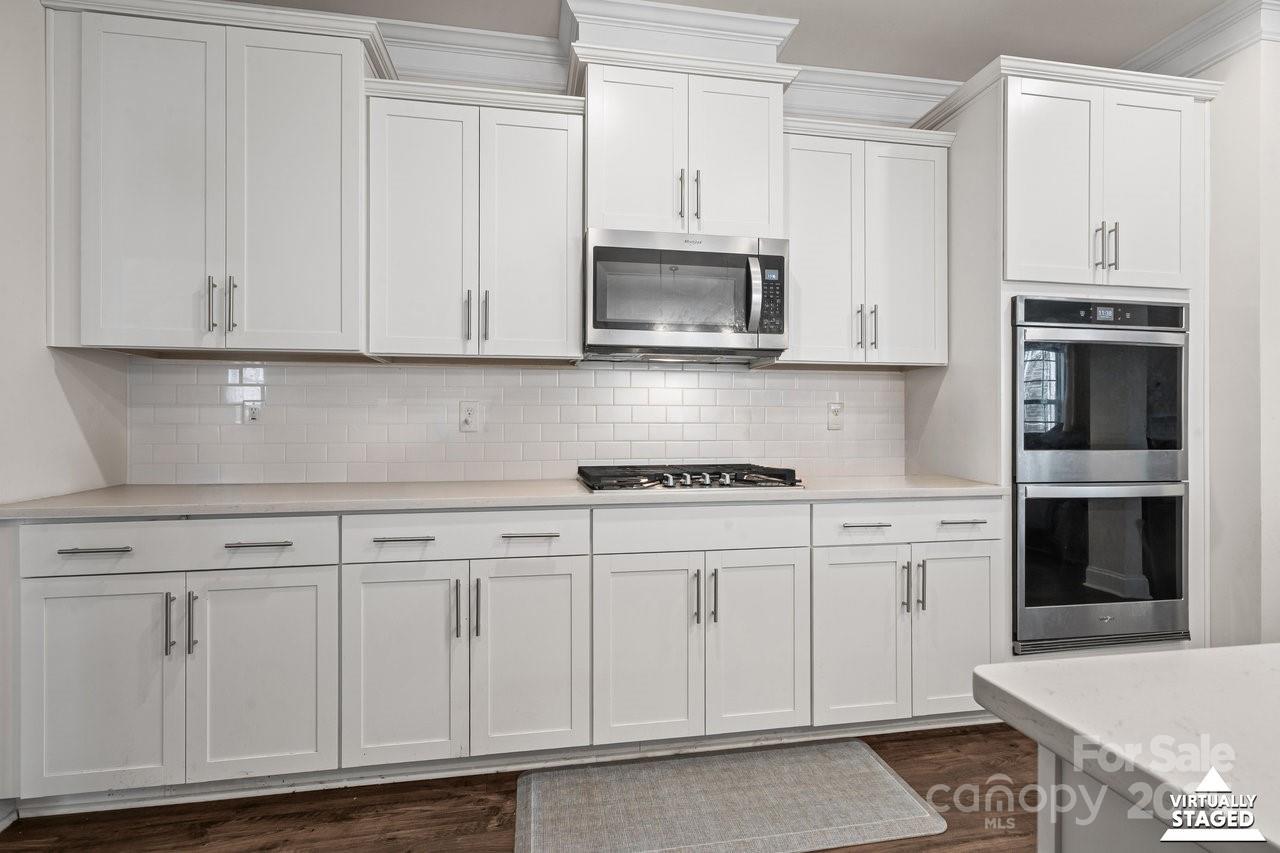 313 Streamwood Road Troutman, NC 28166 - Photo 19 of 48 a kitchen with white cabinets and white appliances
