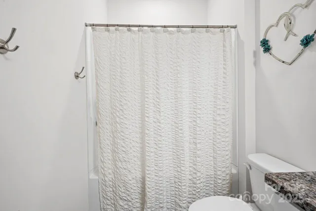 a bathroom with a toilet and a shower curtain