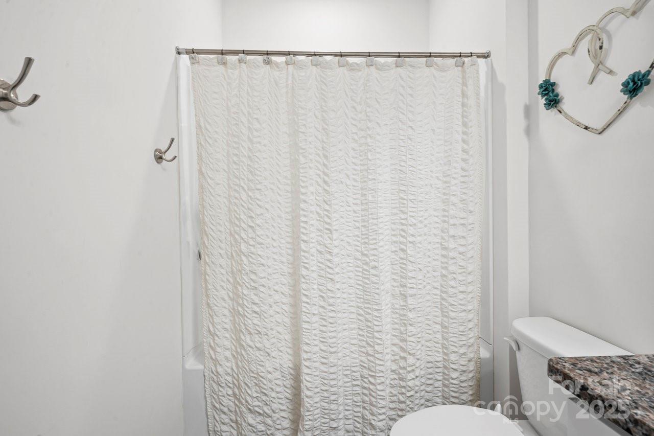 313 Streamwood Road Troutman, NC 28166 - Photo 23 of 48 a bathroom with a toilet and a shower curtain