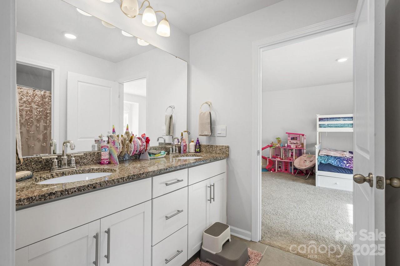 313 Streamwood Road Troutman, NC 28166 - Photo 29 of 48 a en suite bathroom with a double vanity sink and a mirror