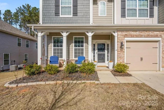 front view of a brick house with potted plants