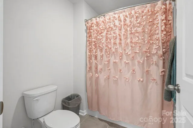 a white toilet sitting next to a shower curtain