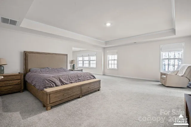 a spacious bedroom with a bed and glass window