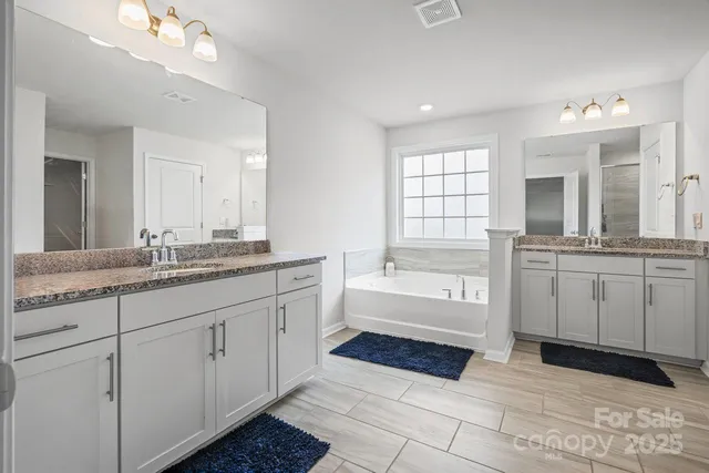 a bathroom with a tub sink and mirror