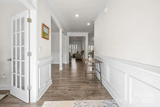 a view of a hallway with wooden floor and staircase