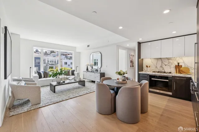 a living room with stainless steel appliances kitchen island granite countertop furniture a rug kitchen view and a window