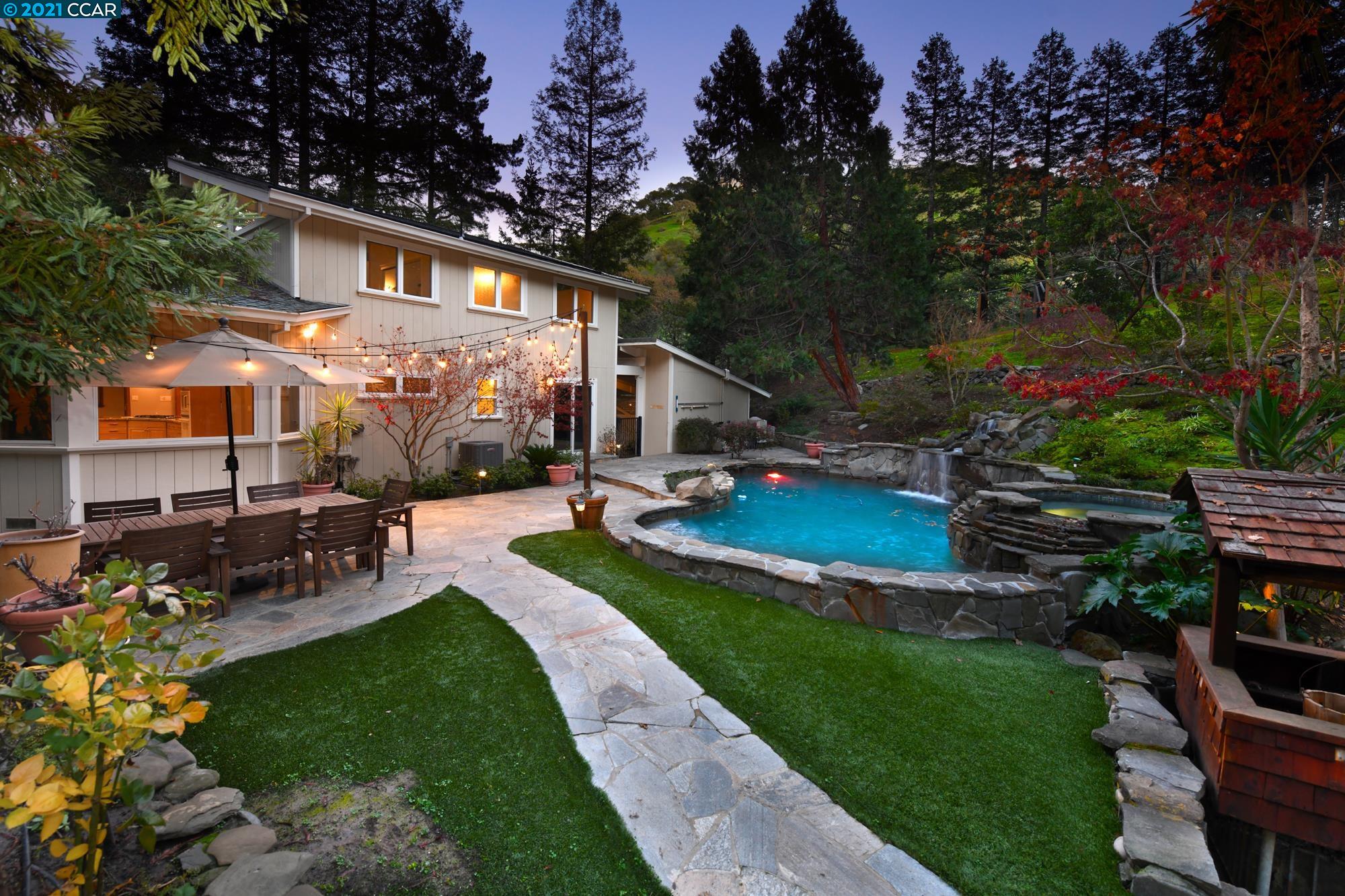 a view of a house with backyard sitting area and garden
