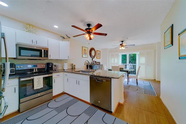 a kitchen with stainless steel appliances granite countertop a refrigerator and a stove top oven