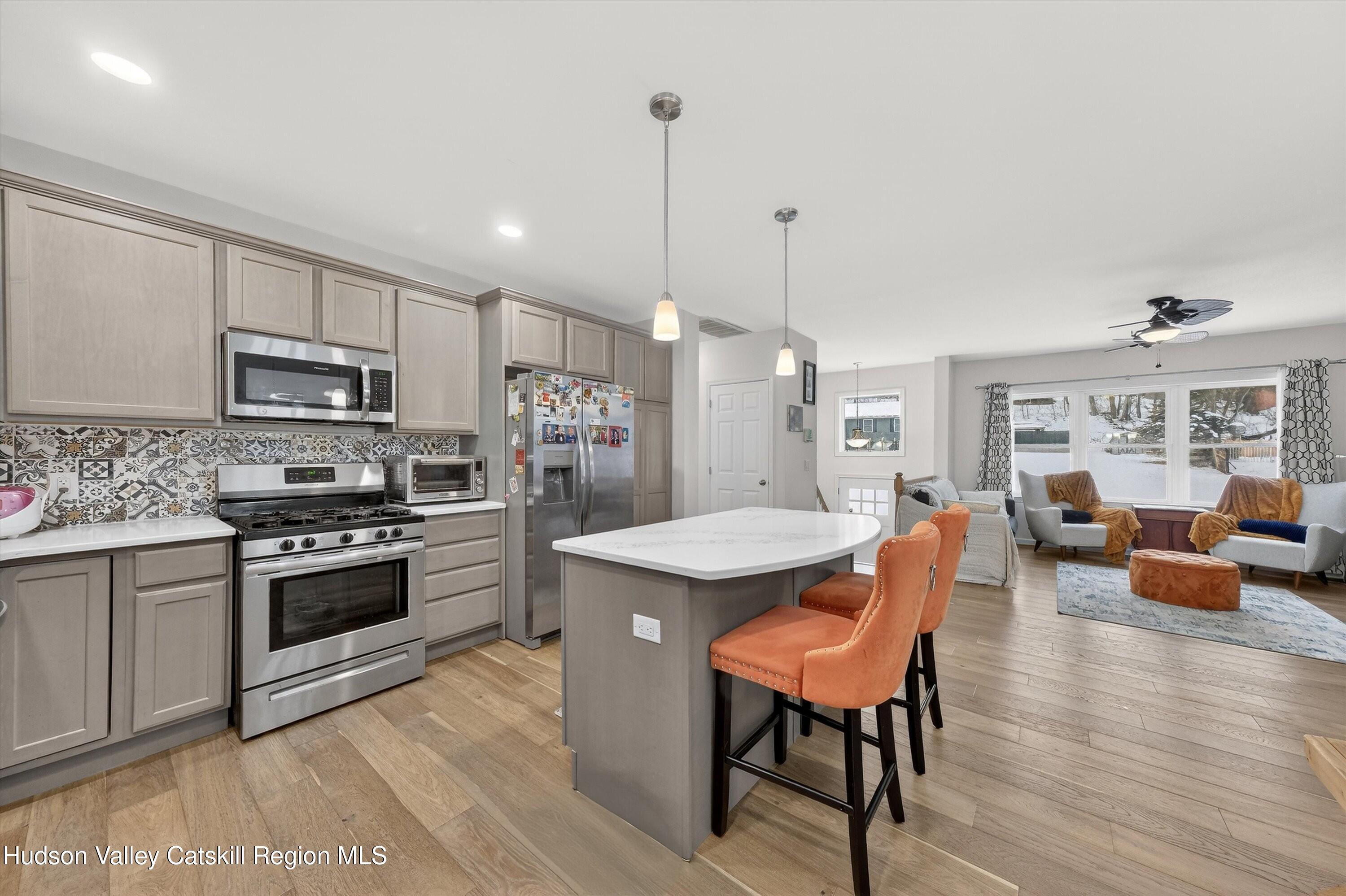 5 3rd Street Milton, NY 12547 - Photo 12 of 31 a kitchen with stainless steel appliances granite countertop a stove top oven a sink dishwasher a dining table and chairs with wooden floor