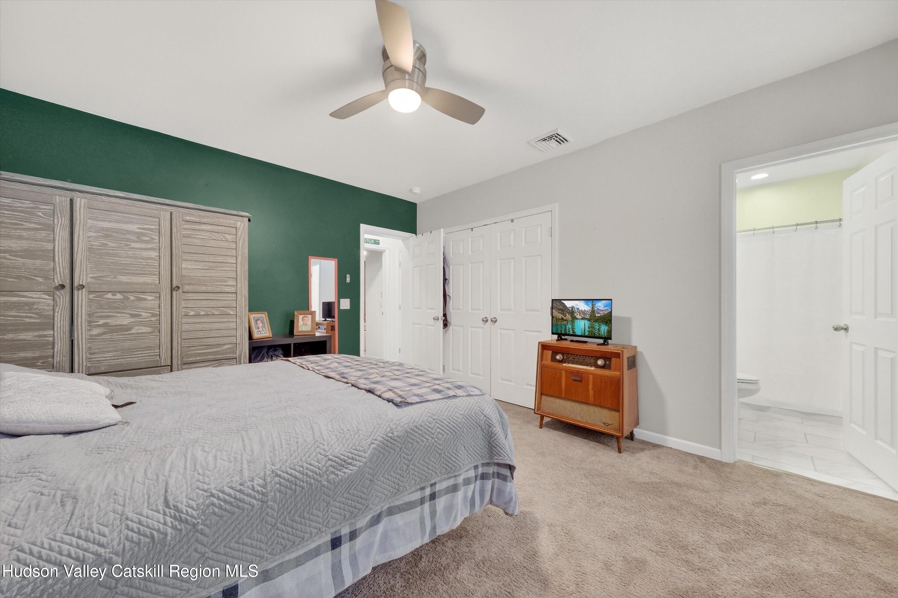 5 3rd Street Milton, NY 12547 - Photo 15 of 31 a bedroom with a large bed and a chandelier