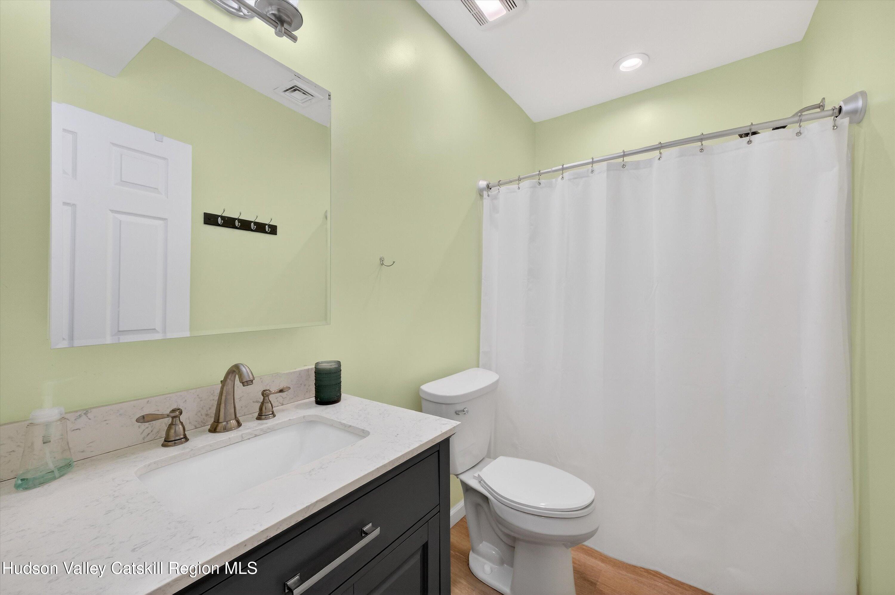 5 3rd Street Milton, NY 12547 - Photo 20 of 31 a bathroom with a granite countertop sink toilet and a mirror