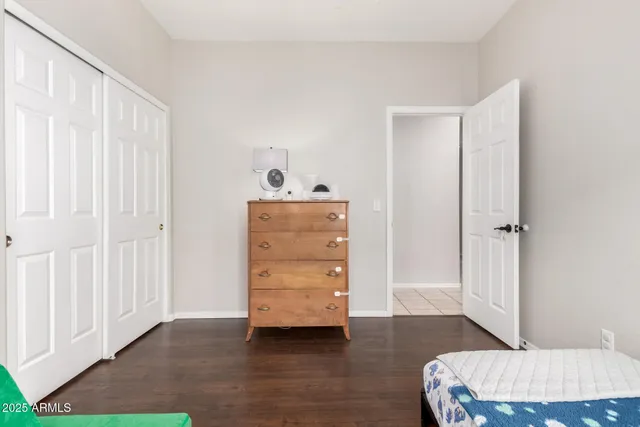a room with a baby crib and dresser