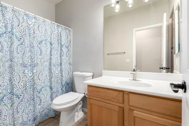 a bathroom with a sink a toilet and a mirror