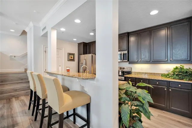 a kitchen with stainless steel appliances kitchen island granite countertop a refrigerator and a stove top oven