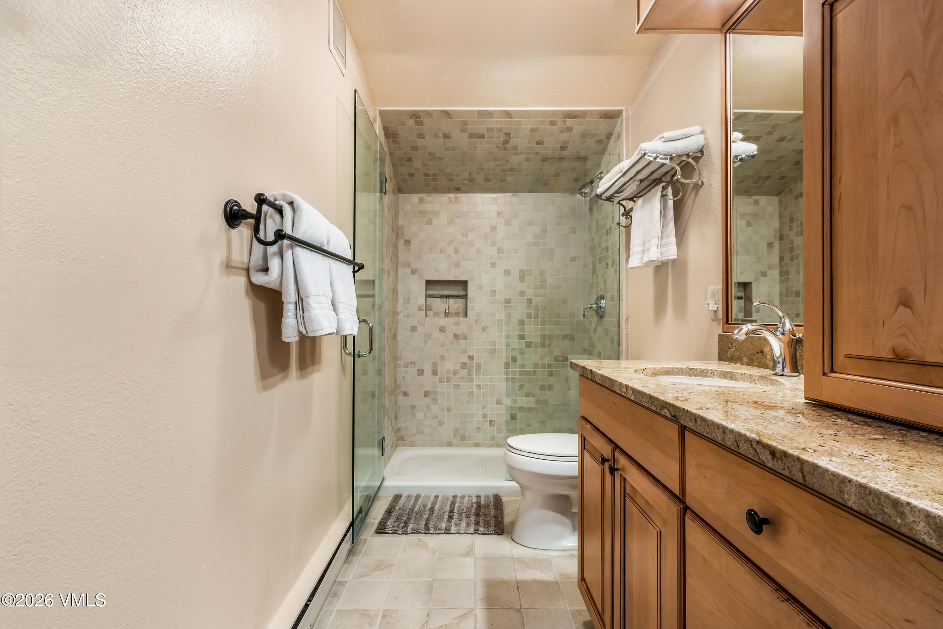 137 Benchmark Road, Unit 605 Avon, CO 81620 - Photo 19 of 30 a bathroom with a granite countertop sink a toilet and shower