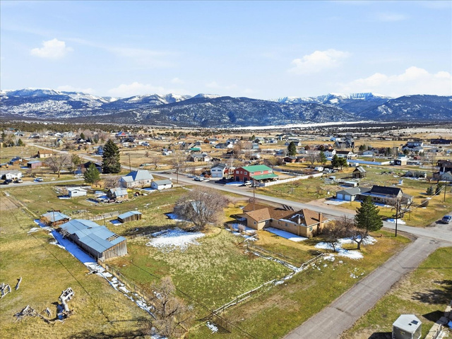 217 East 400 South Spring City, UT 84662 - Photo 2 of 71 Aerial view of property and surrounding area with a mountainous background and nearby suburban area