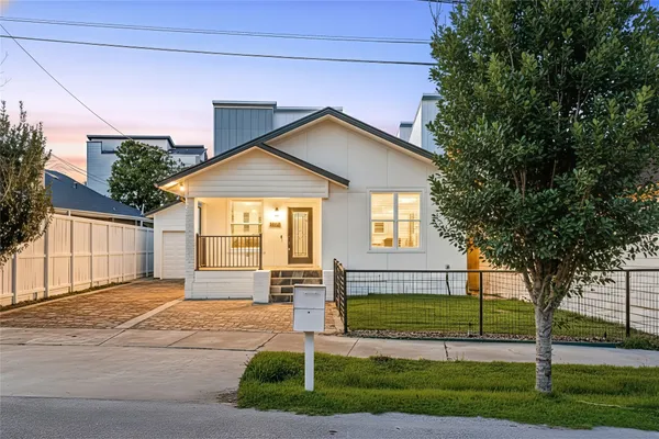 a front view of a house with a garden and yard