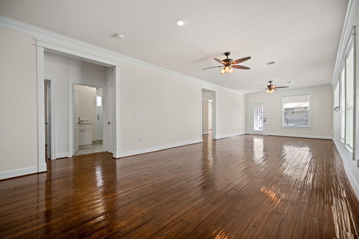 110 Kendall Street Houston, TX 77003 - Photo 11 of 36 an empty room with wooden floor chandelier fan and windows