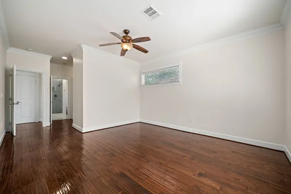 a view of a room with wooden floor and ceiling fan