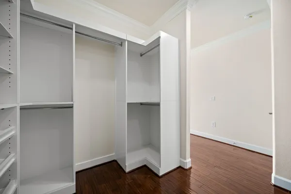 a view of an empty walk in closet with wooden floor