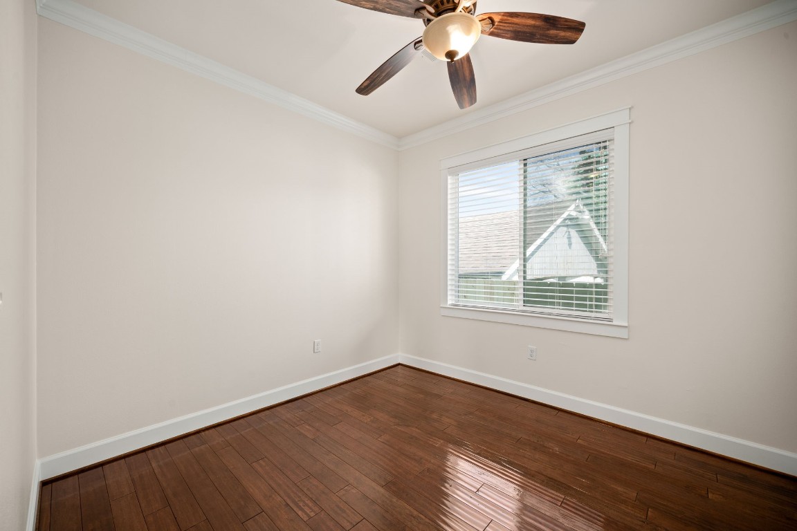 110 Kendall Street Houston, TX 77003 - Photo 17 of 36 an empty room with wooden floor chandelier fan and windows