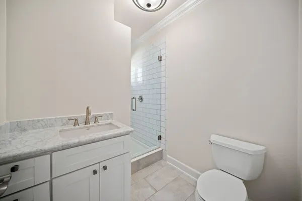 a bathroom with a granite countertop toilet and a sink