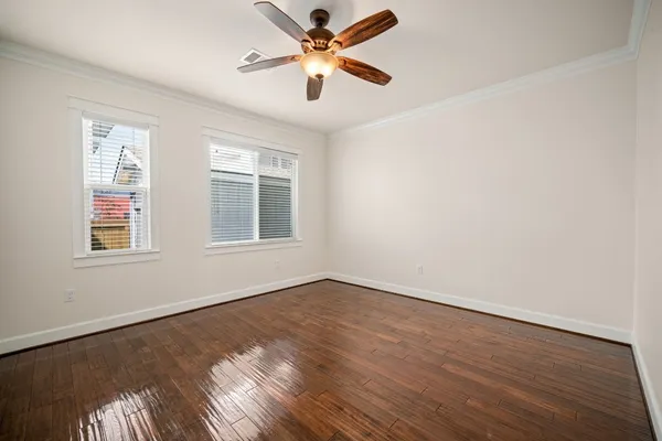 a view of an empty room with window and wooden floor
