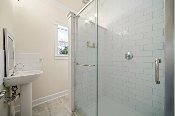 a bathroom with a sink shower and a mirror