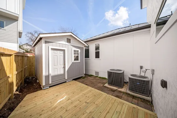 a front view of a house with barbeque grill and wooden fence