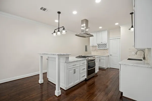 a kitchen with a stove and a wooden floor