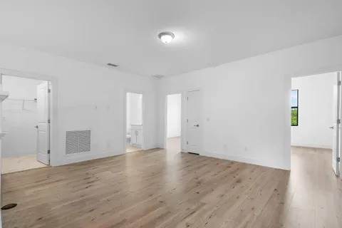 an empty room with wooden floor & bathroom