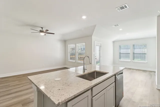 a kitchen with a sink a counter space and wooden floor