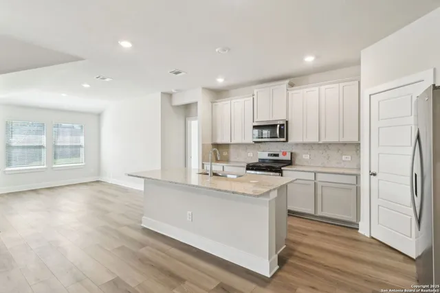 a kitchen with a refrigerator and a stove top oven