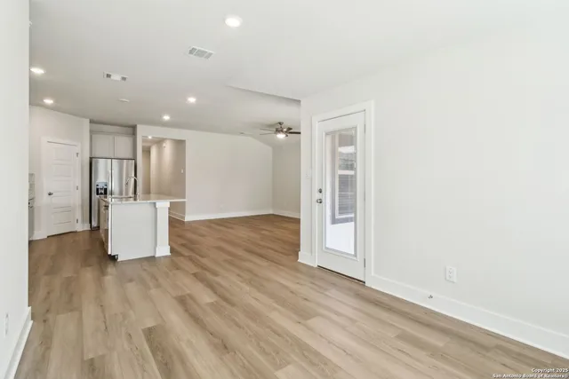 a view of empty room with wooden floor