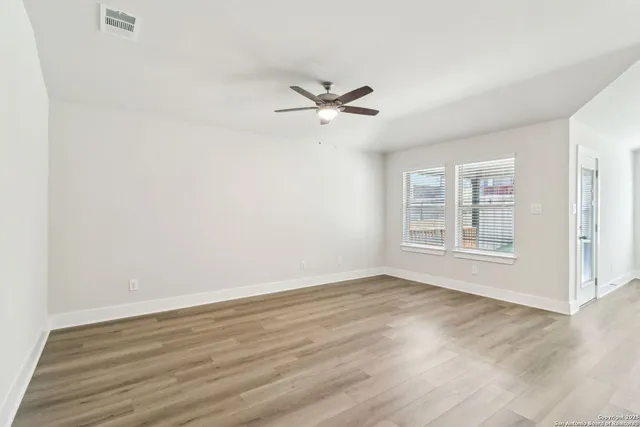 a dining room with furniture a potted plant and wooden floor