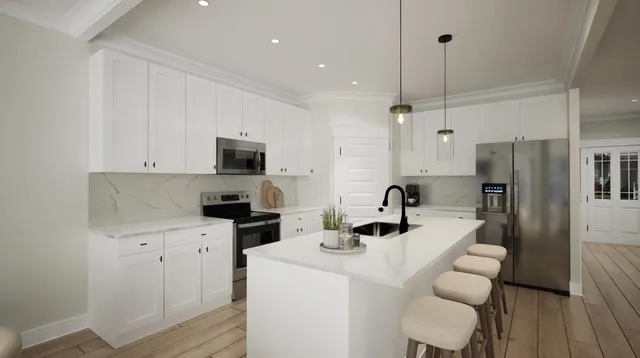 a kitchen with a sink stainless steel appliances and wooden floor