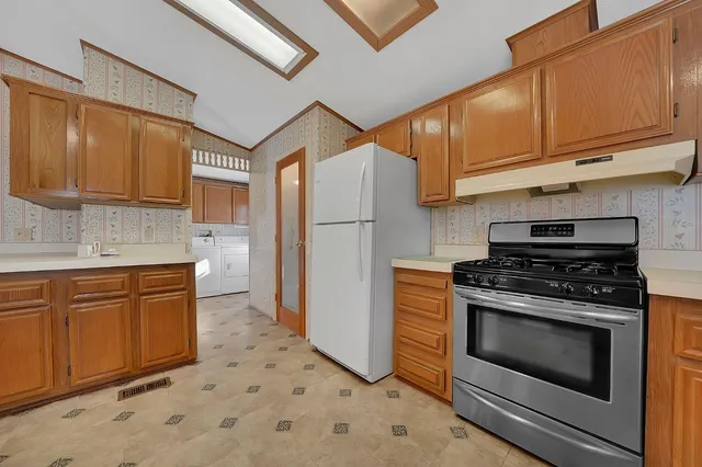 a kitchen with stainless steel appliances granite countertop a stove a sink and a refrigerator