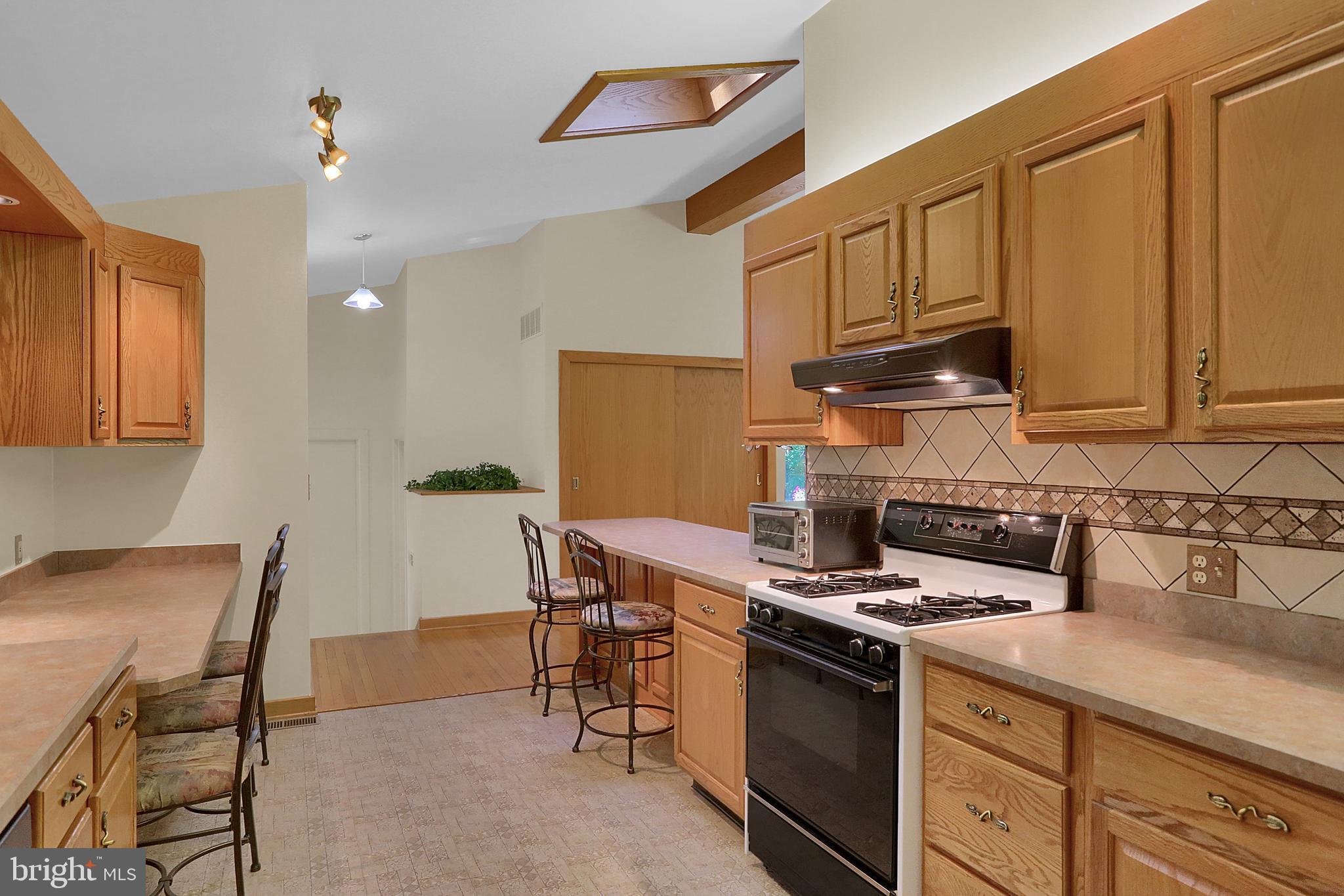 3336 Offutt Road Randallstown, MD 21133 - Photo 14 of 45 a kitchen with stainless steel appliances granite countertop a stove a sink dishwasher and cabinets with wooden floor