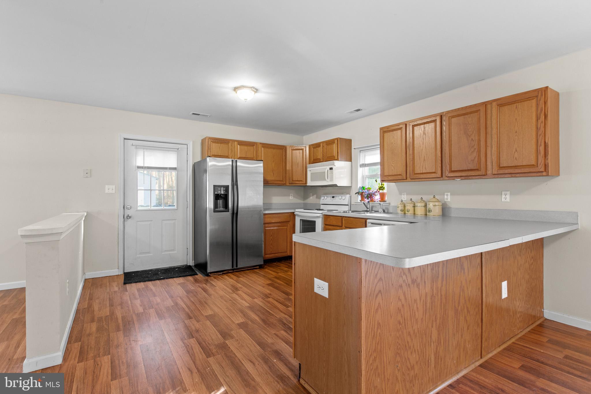 16197 Thomas Road Piney Point, MD 20674 - Photo 4 of 15 a kitchen with stainless steel appliances a refrigerator sink and cabinets