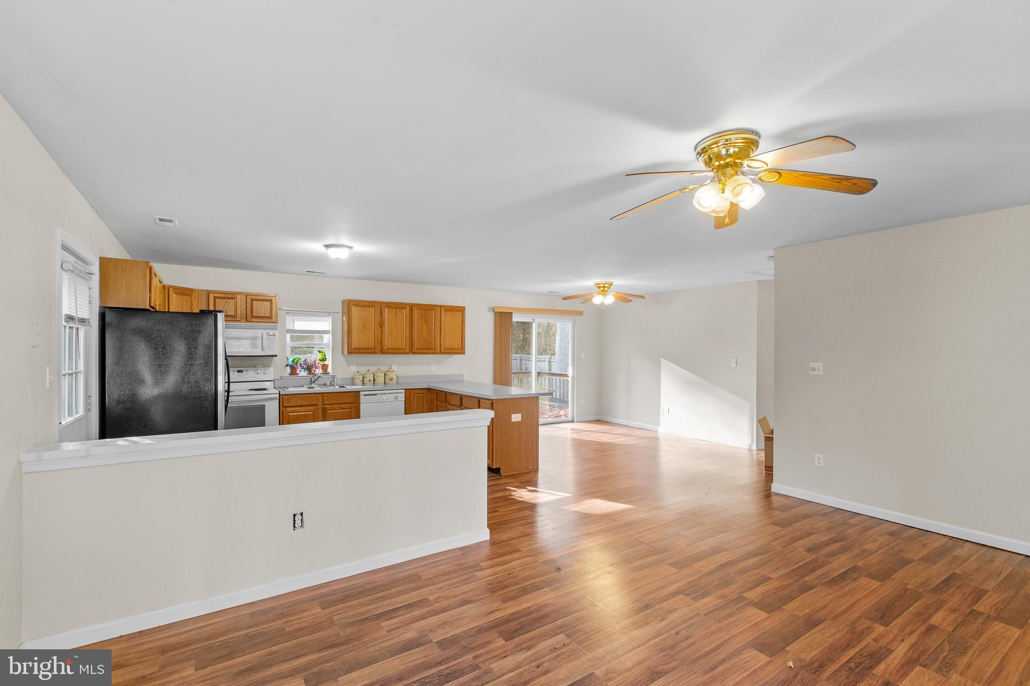 16197 Thomas Road Piney Point, MD 20674 - Photo 5 of 15 a view of a kitchen with wooden floor and a flat screen tv