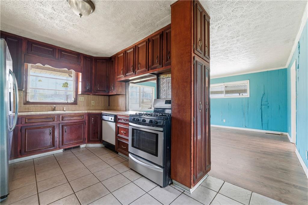 948 Powder Springs Street Marietta, GA 30064 - Photo 15 of 24 a kitchen with stainless steel appliances granite countertop a stove and a refrigerator