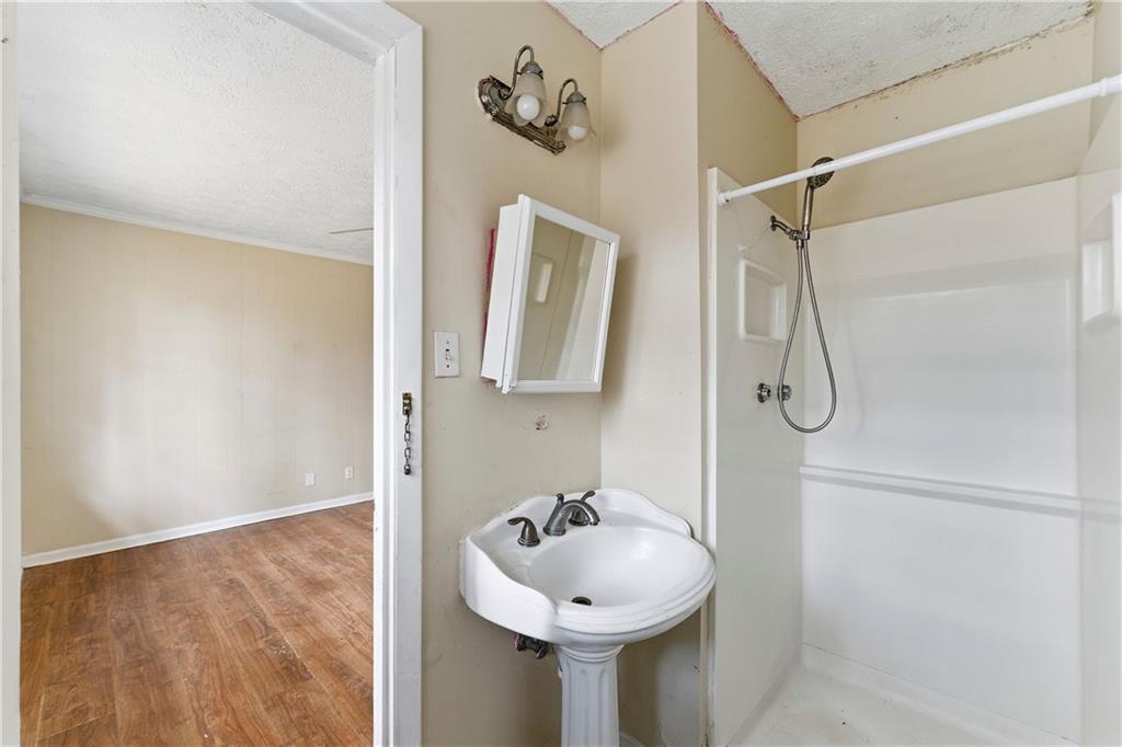 948 Powder Springs Street Marietta, GA 30064 - Photo 17 of 24 a bathroom with a sink a mirror and shower