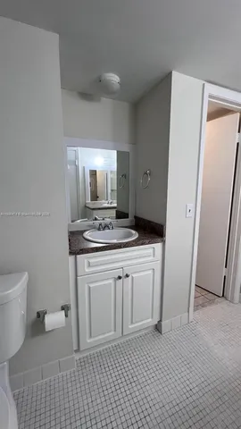 a bathroom with a sink a toilet and a mirror