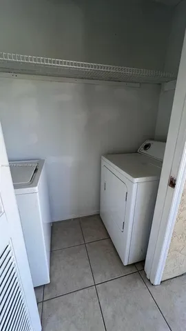 a utility room with cabinets washer and dryer