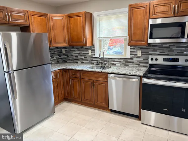 a kitchen with stainless steel appliances granite countertop a refrigerator stove and microwave