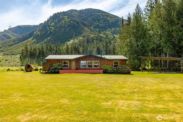 a front view of a house with a large pool and a yard