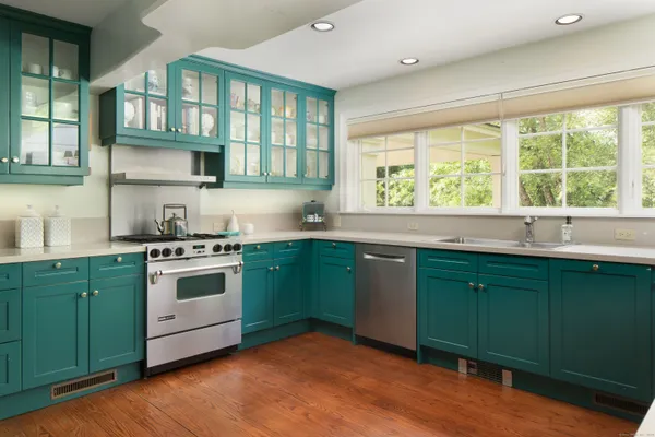 a kitchen with granite countertop a sink stainless steel appliances and a window