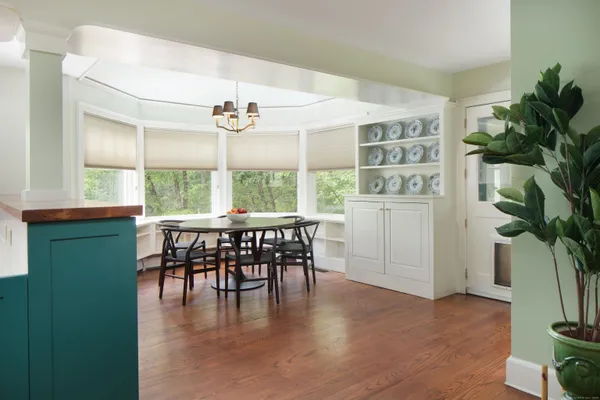 a dining room with furniture potted plants and wooden floor