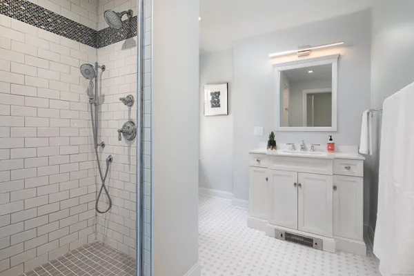 a bathroom with a granite countertop shower sink and mirror